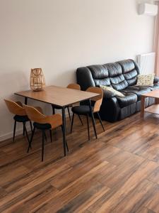 a table and chairs in a living room with a couch at Apartament Lniany in Leszno