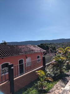 a pink house with a balcony at Casa encanto das Gerais in Tiradentes