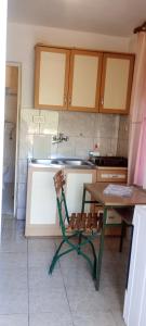 a kitchen with a table and a table and a chair at Apartman Laura 3 in Kamenari