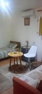a room with a table and a chair and a bed at Apartman Laura 3 in Kamenari