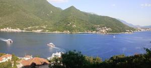 two boats in a large body of water with mountains at Apartman Laura 3 in Kamenari +2 photos