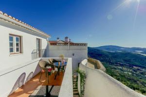 a balcony of a house with a table and chairs at Dom Dinis Marvão in Marvão