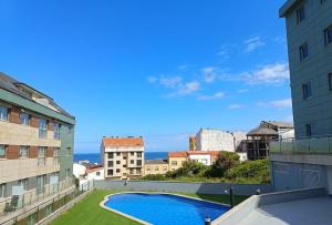 a view from the balcony of a building with a swimming pool at Las gaviotas,playa,piscinayparking in Malpica