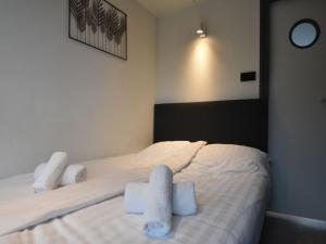 a bedroom with a bed with two white towels on it at Boot zonder naam in Volendam