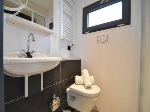 a white bathroom with a sink and a toilet at Boot zonder naam in Volendam +16 photos