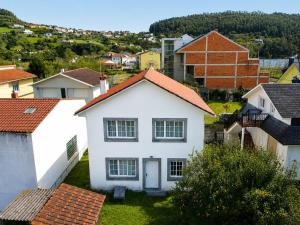 a white house in the middle of a group of houses at Airtegal Casa da Praia Cedeira in Cedeira