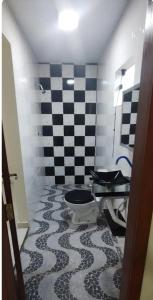 a bathroom with a toilet and a checkered floor at Casa Inteira com Garagem, no Goiabal até 3 hospedes in Macapá +23 photos