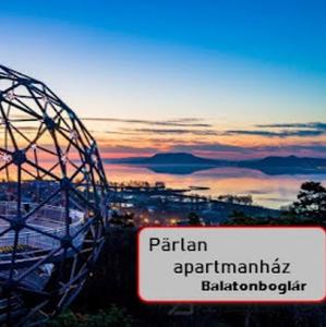 a ferris wheel with a sign in front of a sunset at Pärlan 2 in Balatonboglár