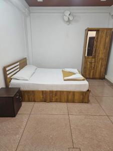 a bedroom with a bed with a wooden frame and a window at Relaxinn Dwaraka in Mānantoddy