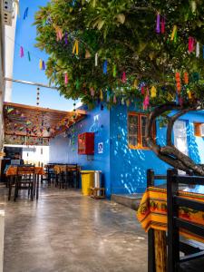 a restaurant with a blue wall and a tree with flags at Hotel Illariy Wasi in Arica