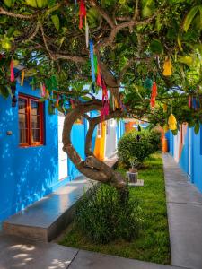 a tree with colorful flags hanging from a building at Hotel Illariy Wasi in Arica