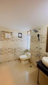 a bathroom with a toilet and a shower and a sink at Hotel The Grand Hyatt Dhaka in Dhaka