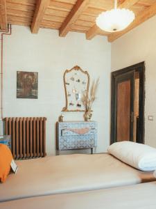 a bedroom with a bed and a mirror and a radiator at Relais il Convento in Palazzago