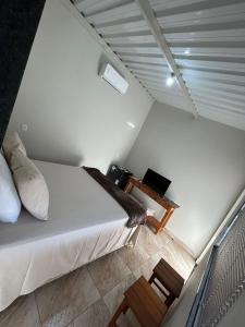 a small bedroom with a bed and a table at Cerrado da Canastra Chalé Quartinho simples in São Roque de Minas