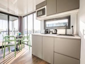 a kitchen with white cabinets and a table with chairs at Marina Sunrise in Volendam