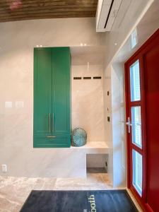 a green cabinet in a room with a window at Flatanger Turkish Bath apartment in Lauvsnes