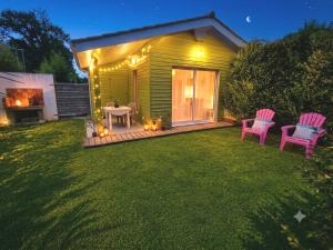 a backyard with two chairs and a table and a fireplace at Gîte 2 pers avec jardin entre Bordeaux & Lacanau Océan in Brach +5 photos