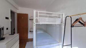 a white bunk bed in a room with a closet at Pescadores GuestHouse in Costa da Caparica +30 photos