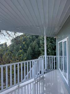 a porch of a house with a white railing at Casa Azul Mountain Resort in Nathia Gali