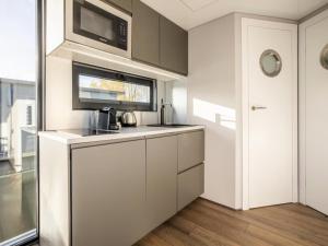 a kitchen with white cabinets and a microwave at Marina Sunrise in Volendam +11 photos