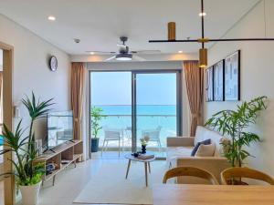 a living room with a couch and a view of the ocean at The Song Apartment Vung Tau - Căn Hộ Du Lịch 5 Sao Cạnh Biển Vũng Tàu in Vung Tau
