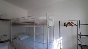 a bedroom with a bunk bed with a ladder and shoes at Pescadores GuestHouse in Costa da Caparica