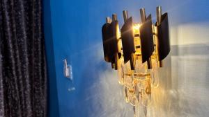 a chandelier is hanging from a blue wall at RR palace in Pachmarhī