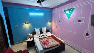 a bedroom with a bed with a purple wall at RR palace in Pachmarhī