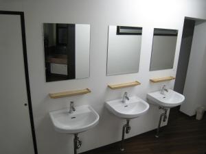 a bathroom with two sinks and two mirrors at Hotel Eco Dogo in Matsuyama