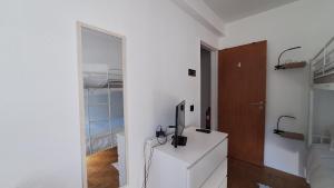 a white room with a desk with a television on it at Pescadores GuestHouse in Costa da Caparica