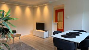 a living room with a table with chairs and a tv at Arya villa in Bergen