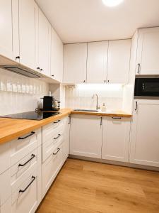 a white kitchen with white cabinets and a sink at Airtegal Dunas de Cedeira in Cedeira