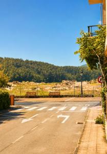 an empty parking lot with two benches on a street at Airtegal Dunas de Cedeira in Cedeira