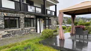 a house with a wooden deck with a gazebo at Arya villa in Bergen