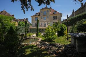 a large house with a pond in front of it at Maison Les Étoiles chambres d'hôtes de charme avec jardin paisible et petit déjeuner à Tonnerre in Tonnerre