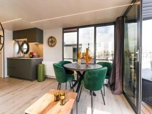 a kitchen and dining room with a table and green chairs at Le Belle Vie in Volendam +14 photos