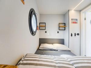 a bedroom with two beds and a clock on the wall at Le Belle Vie in Volendam