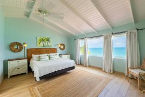 a bedroom with a bed with a view of the ocean at Antigua Village Beach Resort in Saint Johnʼs +162 photos
