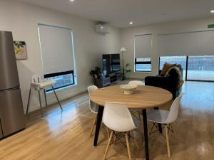 a kitchen and living room with a table and chairs at 3BR Haven in Stony Rise in Tugrah