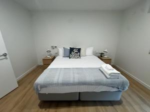 a bedroom with a large bed in a white room at 3BR Haven in Stony Rise in Tugrah