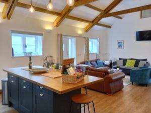a kitchen with a large island in a living room at Vineyard Barns Gower in Swansea