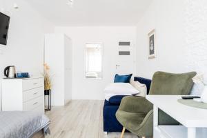 a white bedroom with a blue couch and a bed at Willa Bliźniak 2 - 300m od Plaży Śniadanie W Cenie Pobytu in Karwia