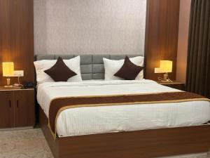 a bedroom with a large bed with two lamps at Raj Hussain Land Mark Hotel in Mayiladuthurai