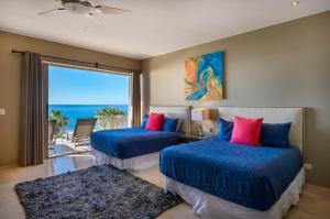 two beds in a bedroom with a view of the ocean at Views to El Arco, Famous Cabo San Lucas bay rock formation in El Pueblito +41 photos