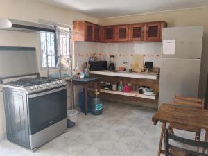 a kitchen with a stove and a refrigerator at Casa León in Bacalar