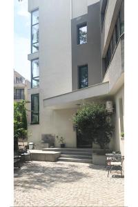a large building with stairs and a tree in front of it at Guesthouse Odesos in Sozopol