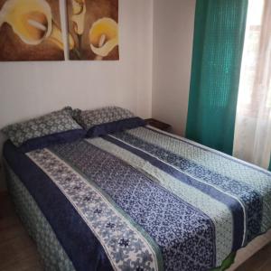 a bed sitting in a room with a window at Mi Guarida in El Tabo