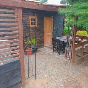a wooden cabin with a table and a door at Mi Guarida in El Tabo