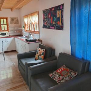 a living room with two couches and a kitchen at Mi Guarida in El Tabo