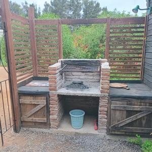 a fireplace in a garden with two benches at Mi Guarida in El Tabo
